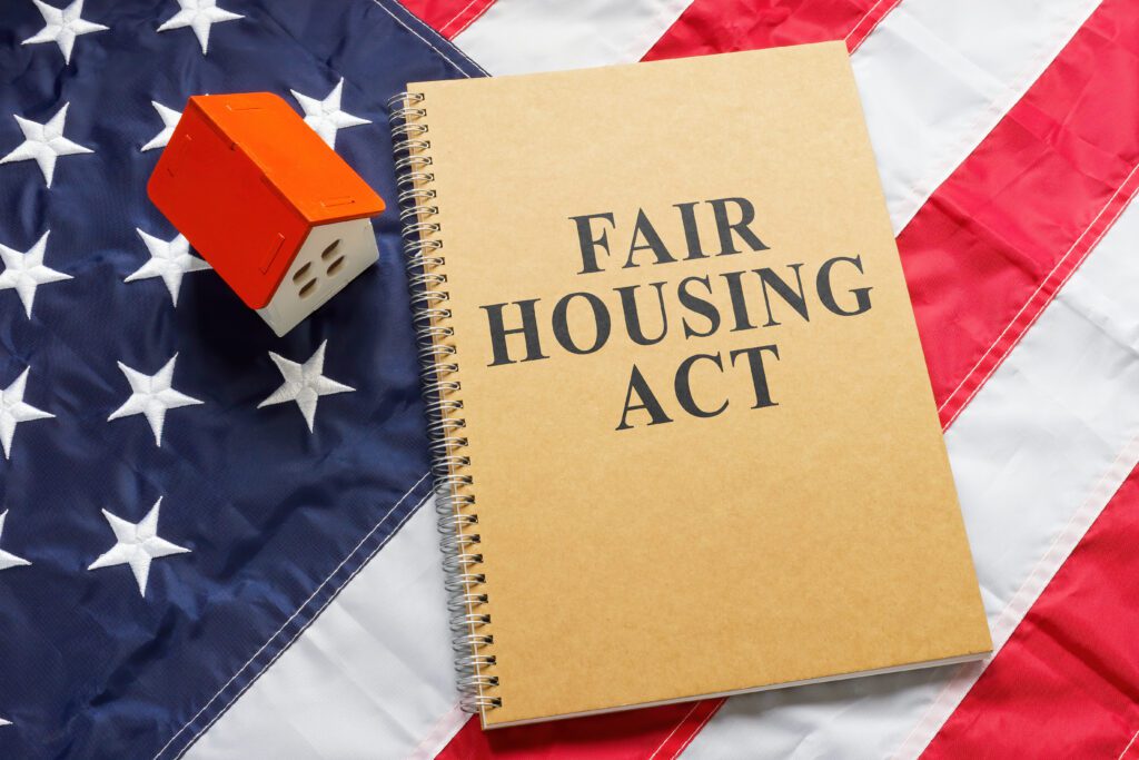 A notebook with the words “Fair Housing Act” on it sitting on an American Flag.