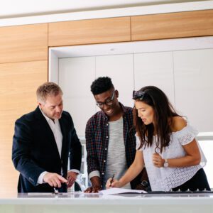 A couple signs a lease with the property owner.
